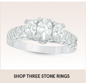 Shop three stone gold engagement rings with the shopping link on this image. The picture shows three main diamonds on ring with other diamonds around the main three diamonds.