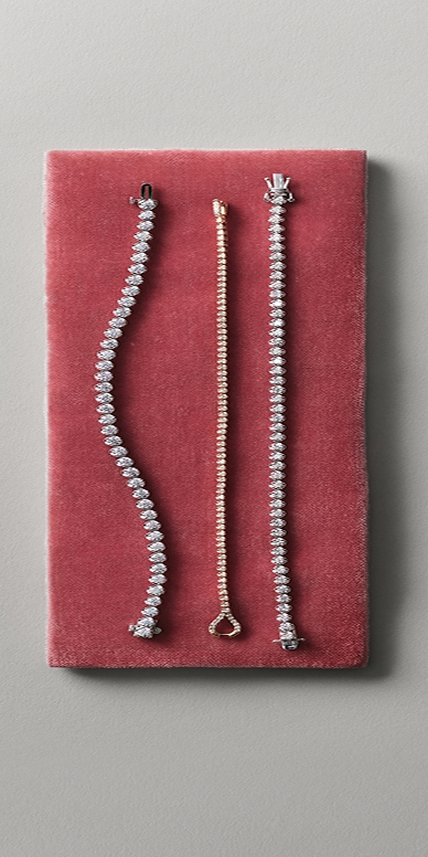 Three tennis bracelets laying flat on display.