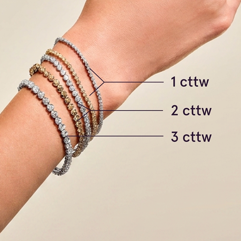 A model wearing varying carat weight diamond tennis bracelets.