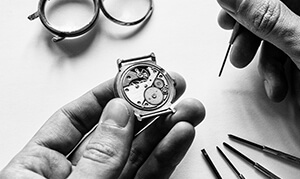 A watchmaker working on the mechanism of a wrist watch