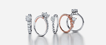 Five different diamond engagement rings set on a gray background
