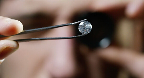A gemologist inspecting a diamond under a microscope