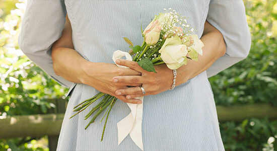 A woman in a blue dress holding a bouquet of white roses